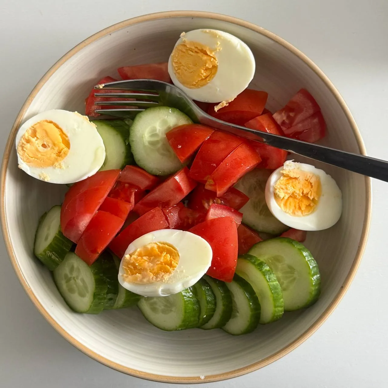 Миска з огірками, помідорами та вареними яйцями як приклад простої страви для підтримання ваги після схуднення