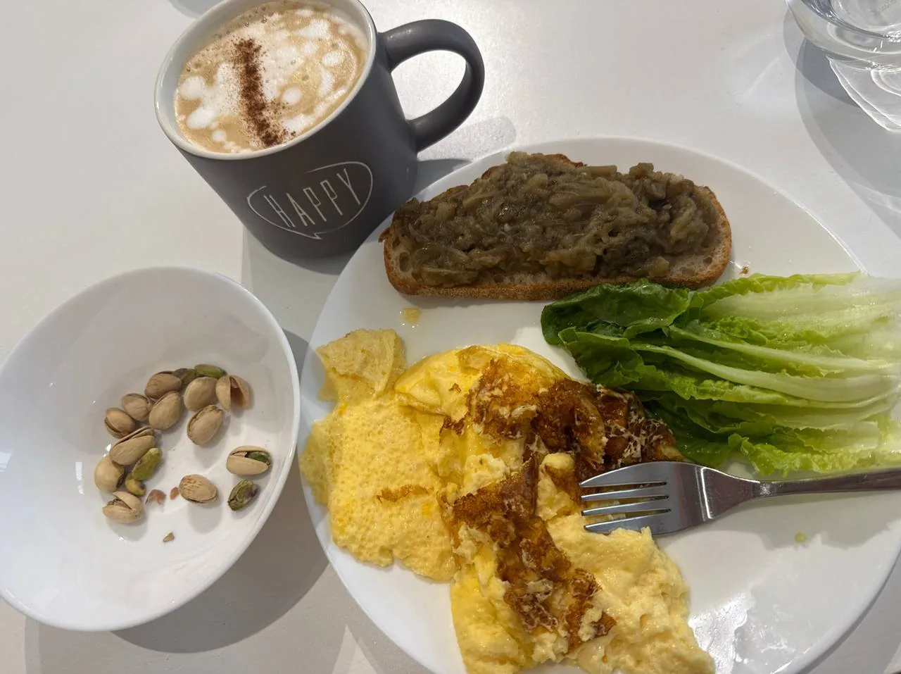 Сніданок з тостом, яєчнею, зеленню, фісташками та кавою як приклад збалансованого прийому їжі при інсулінорезистентності