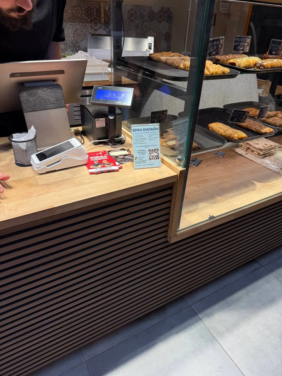 Прилавок пекарні з випічкою, касою та терміналом оплати крупним планом